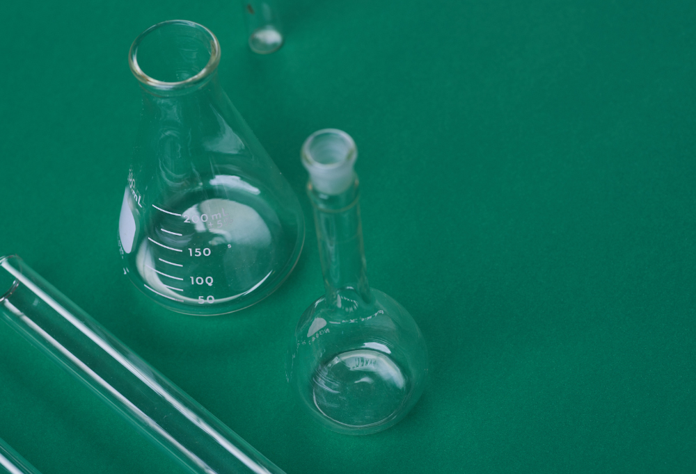 An image of two beakers on a green background.