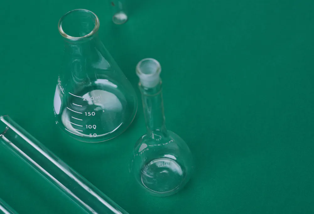 Two beakers on a green background
