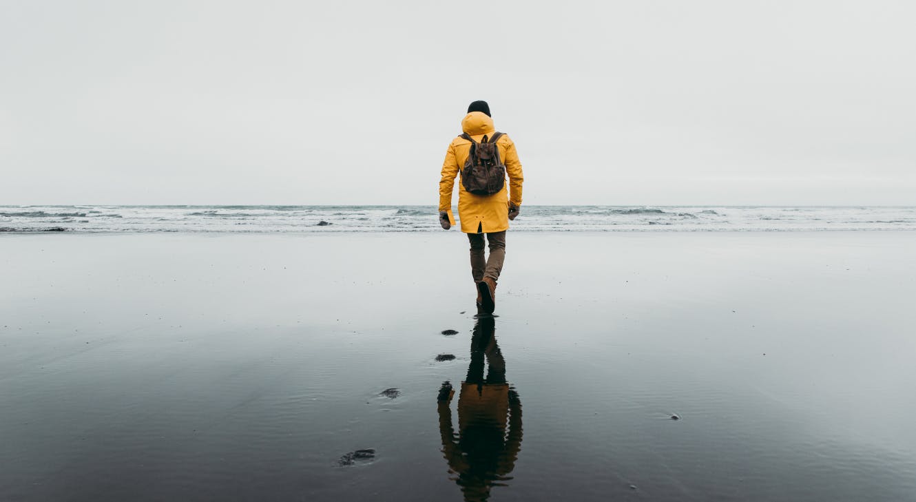  man walking along a beach.