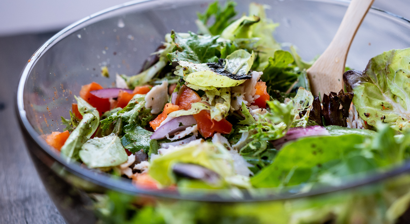 A bowl of salad containing folate-rich leafy greens.