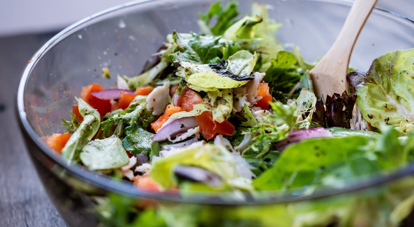 A bowl of salad containing folate-rich leafy greens.