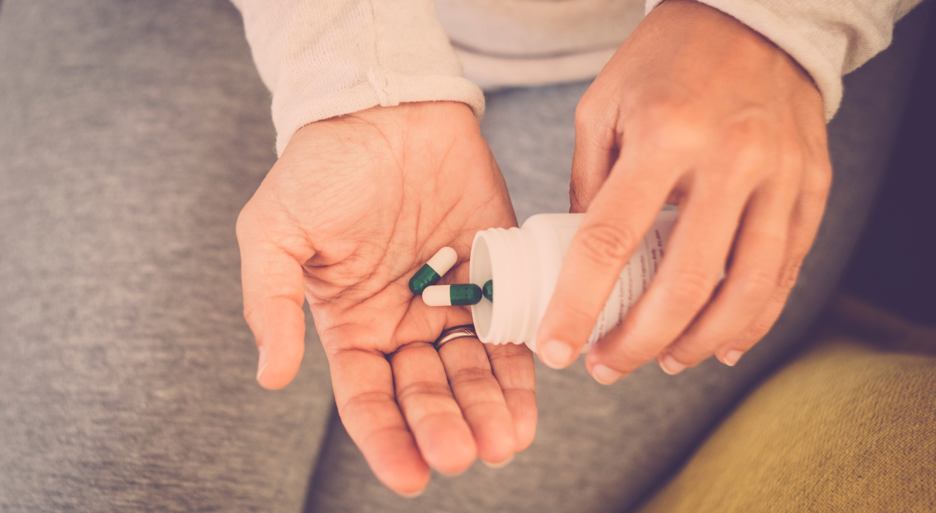A person holding vitamin D pills.