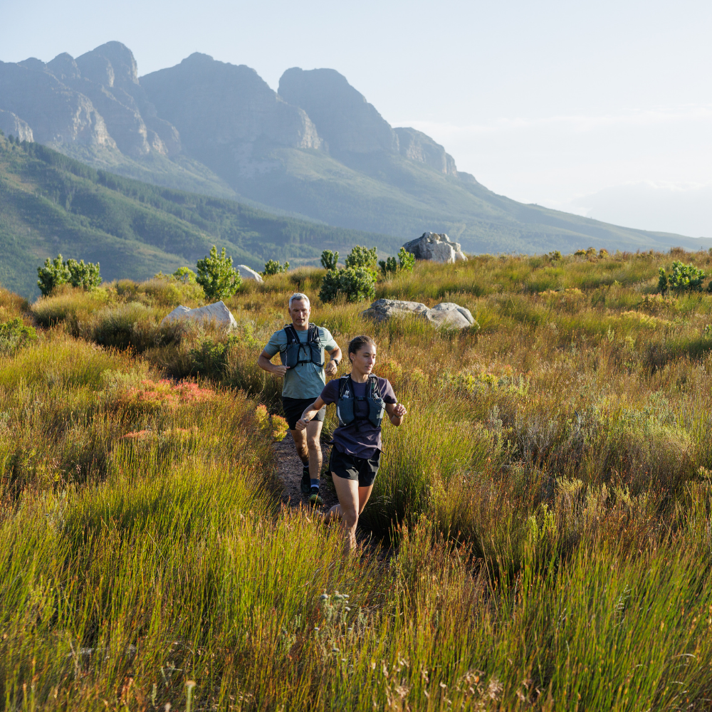 An image of two people running through a field.
