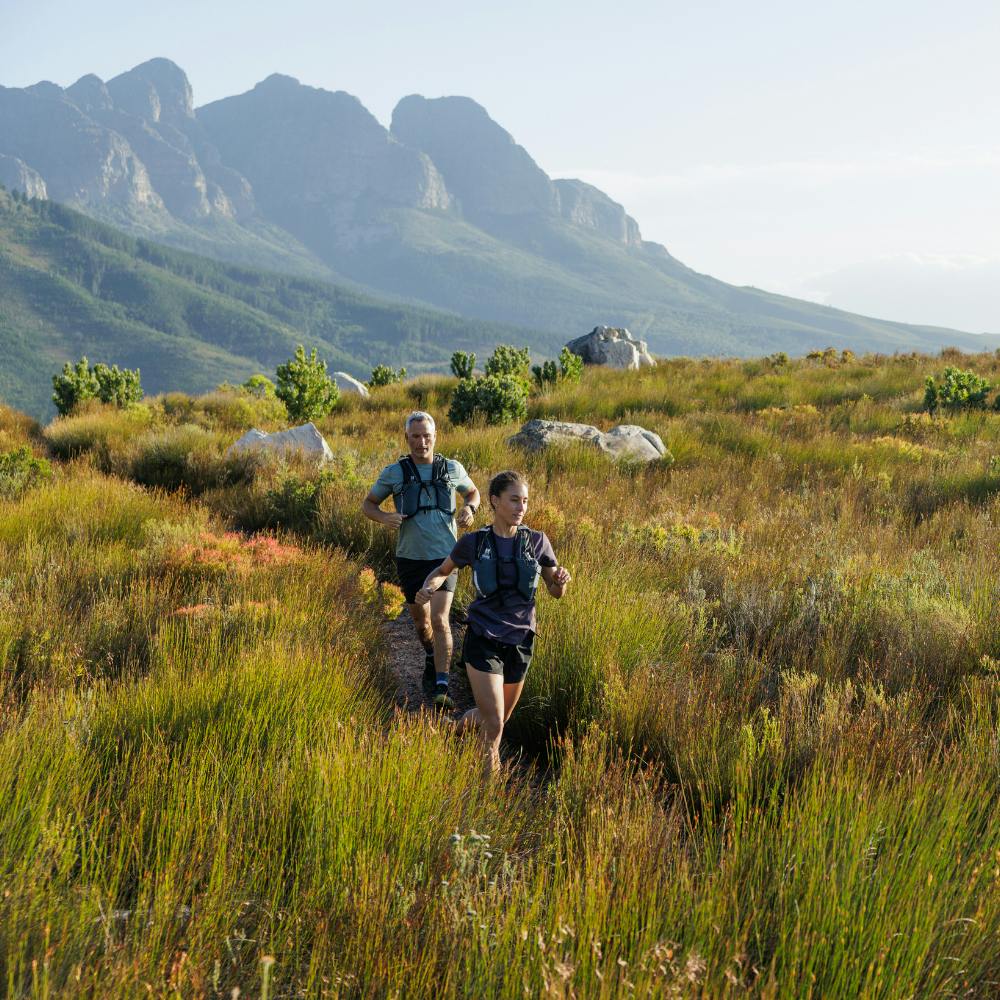 An image of two people running through a field.