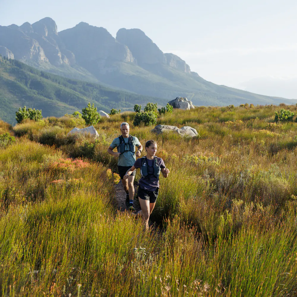 An image of two people running through a field.