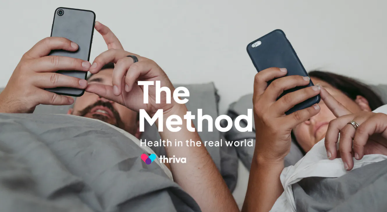 An image of two people in bed on their phones