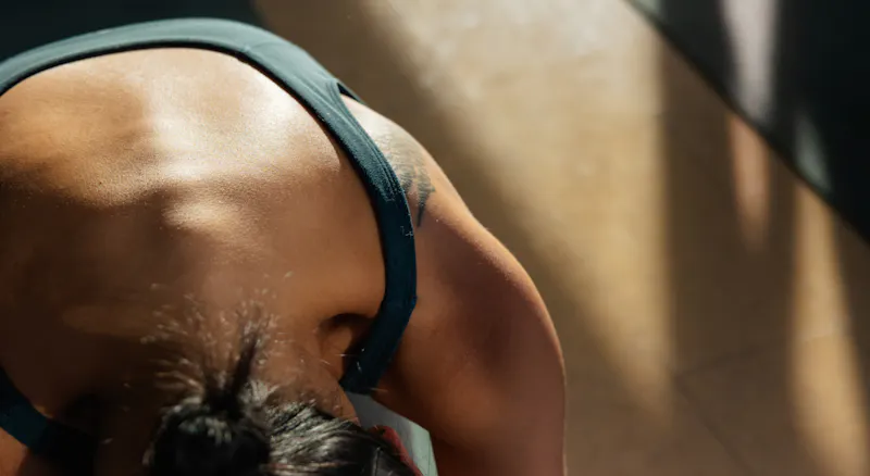 A woman's back while she does yoga.