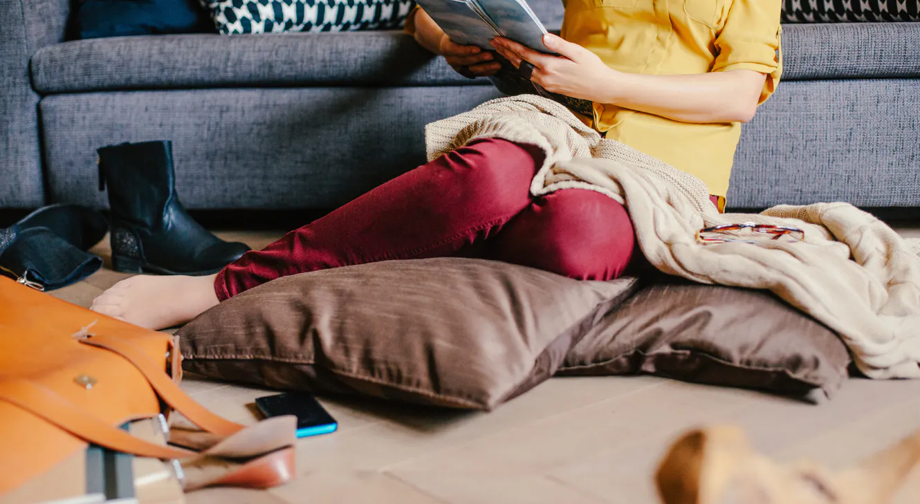 A woman sitting on the floor reading.