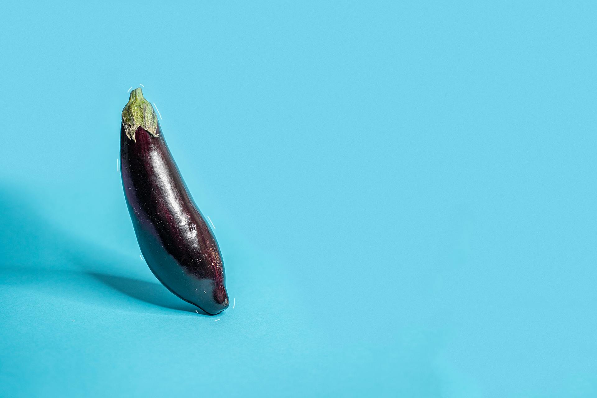 Upright aubergine against blue background