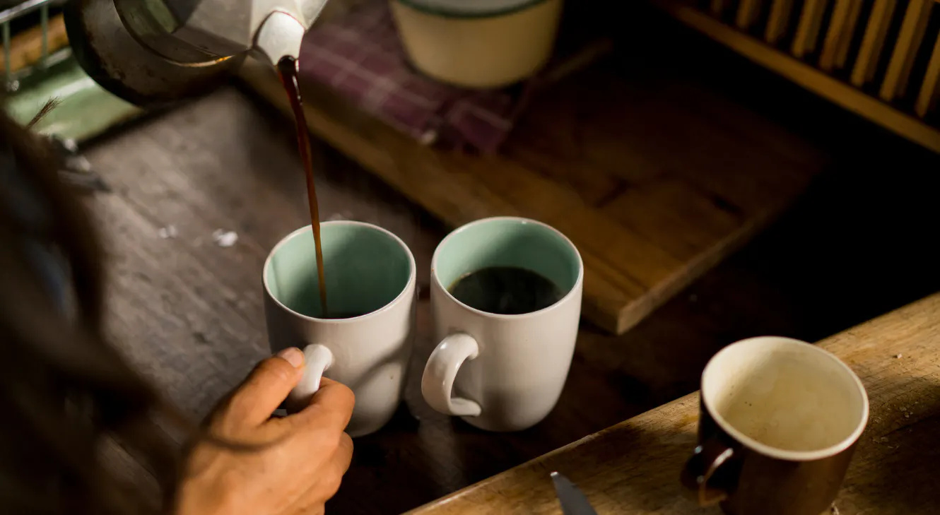 Pouring coffee into two mugs