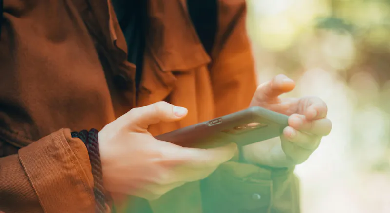A woman using her phone outdoors.