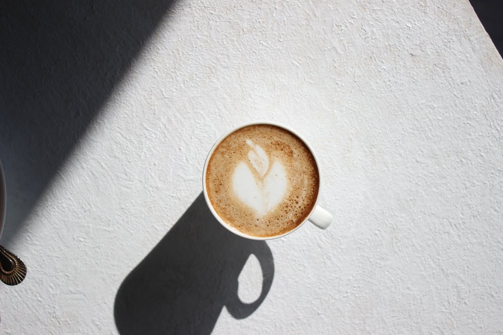 Cup of coffee against white background and shadow