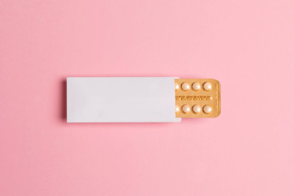 Contraception pills on pink background 