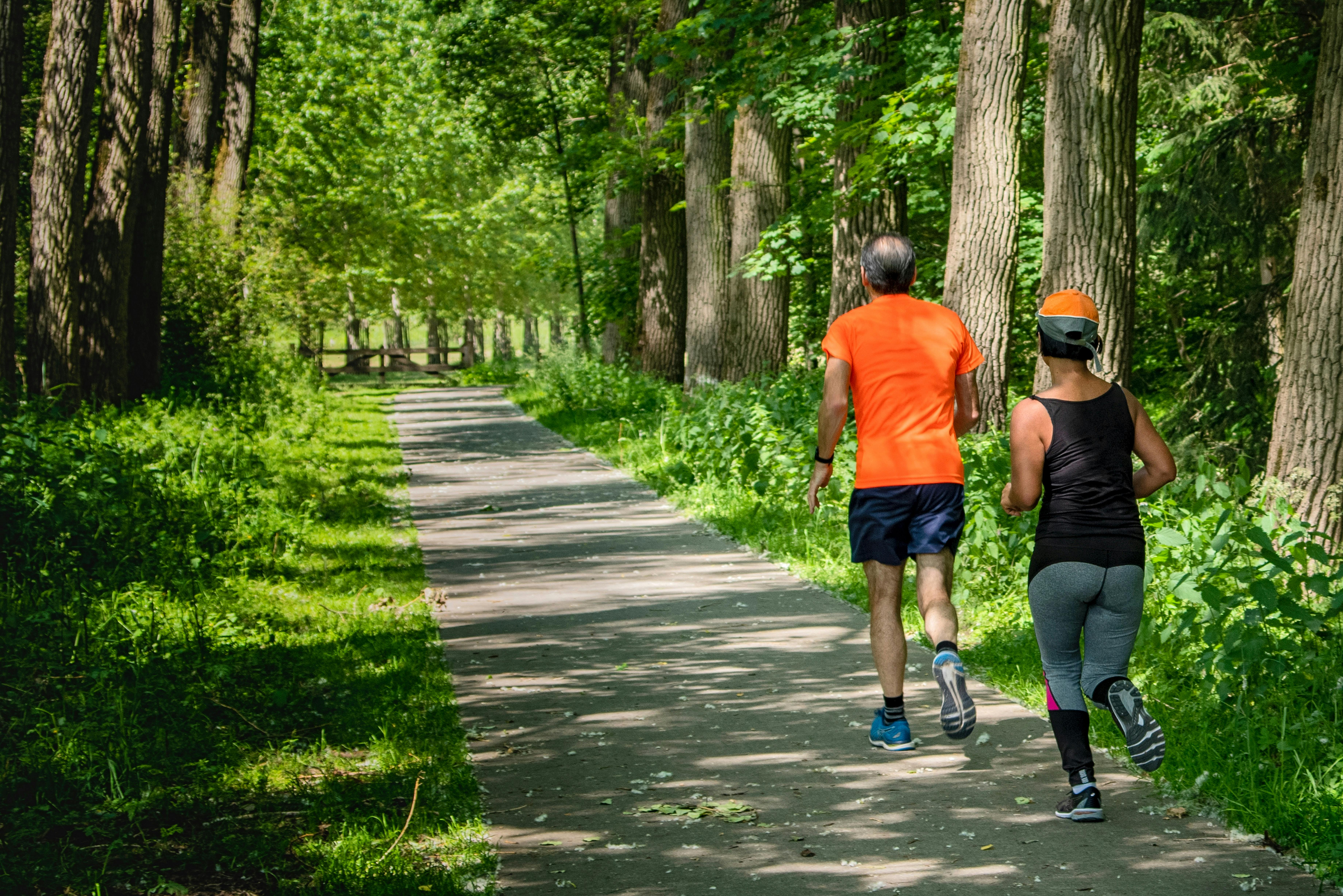 Man and woman jogging on woodland pathway