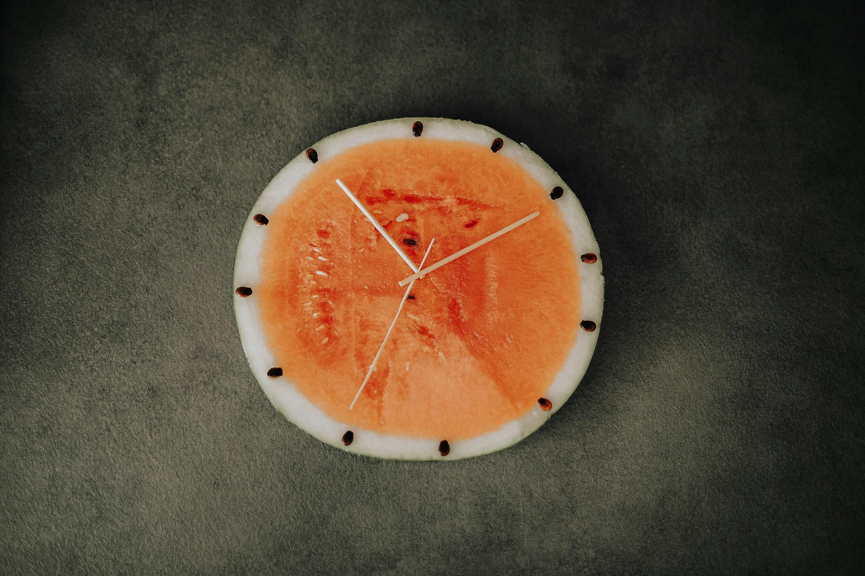 Clock made from watermelon and wooden sticks