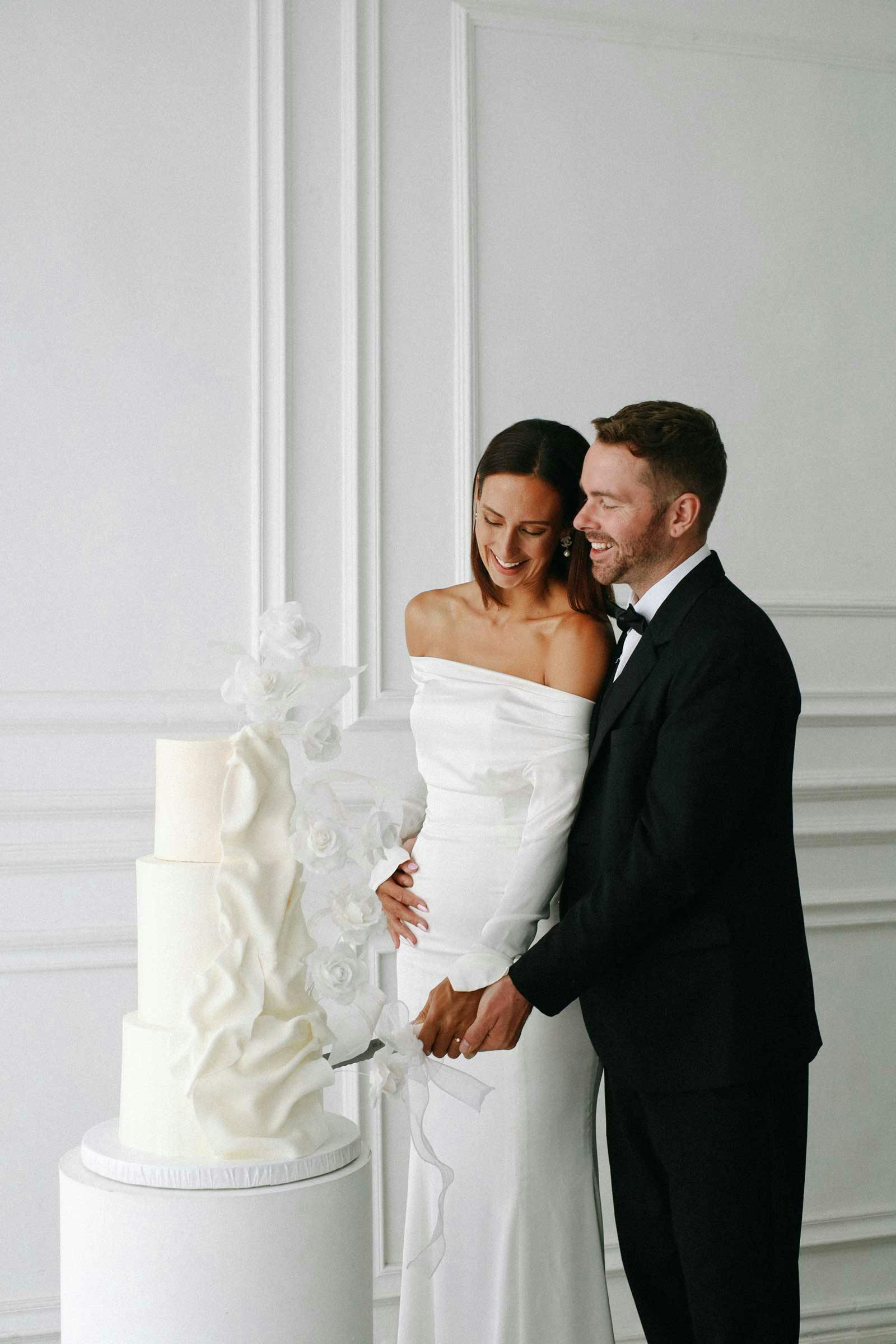 beautiful couple standing next to their wedding cakes in bali