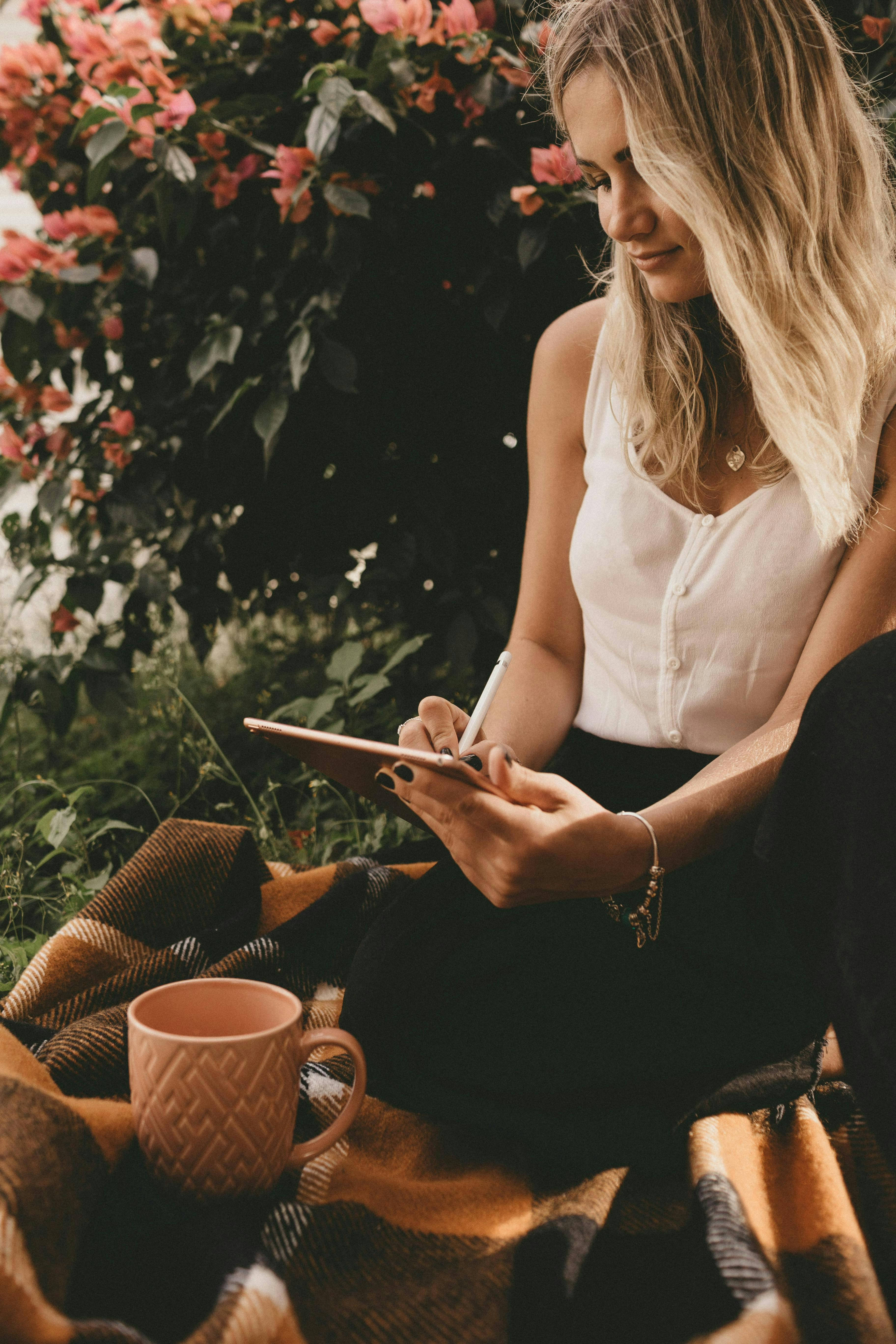 femme assise sur couverture en train d'écrire