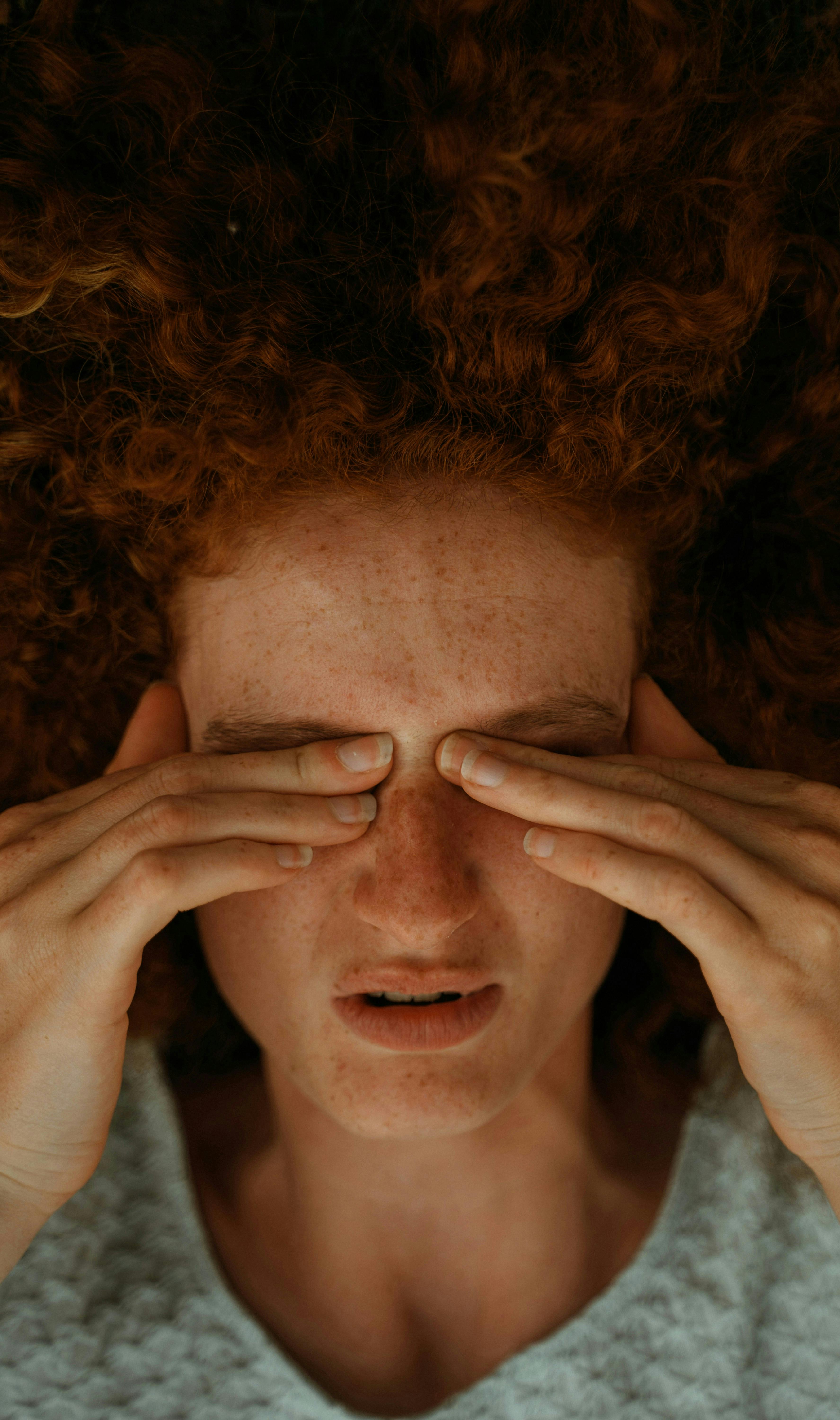 femme rousse qui se ferme les yeux