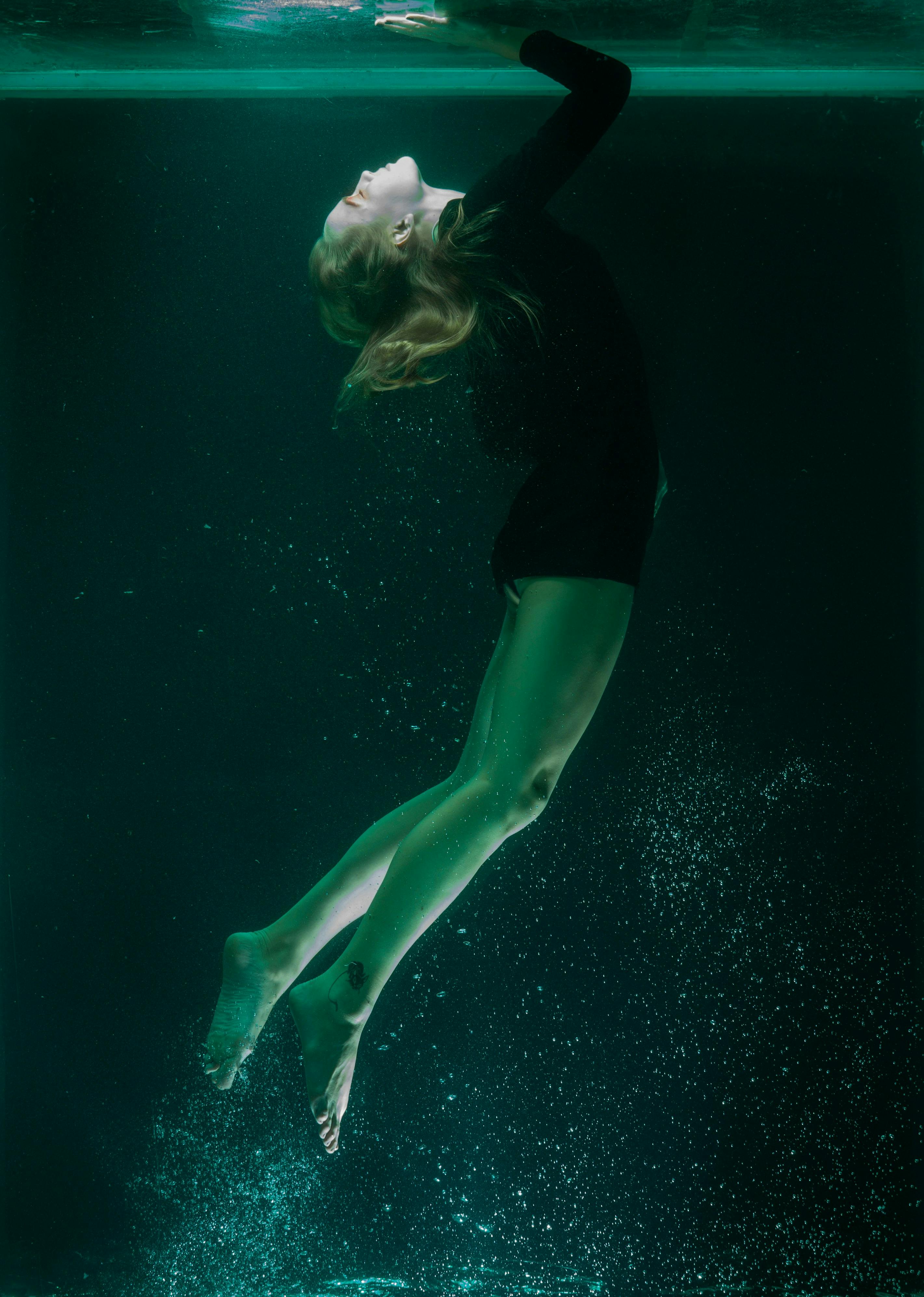 femme sous l'eau  qui remonte vers la surface