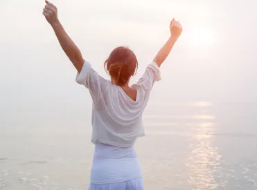 femme happy bras en l'air devant lac