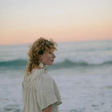 femme devant la mer et coucher de soleil