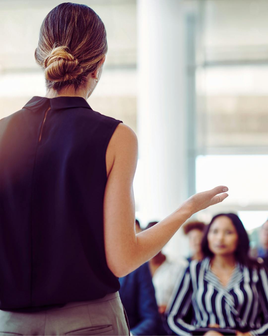 femme de dos qui parle en public