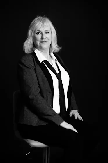 isabelle engel femme assise sur chaise avec cravate