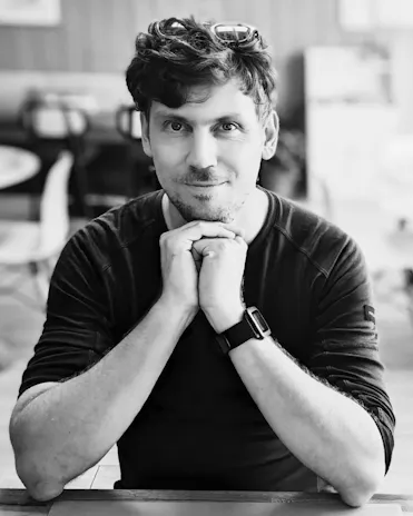 cyrille grossholtz homme avec visage qui repose sur ses mains et lunettes de vue dans les cheveux