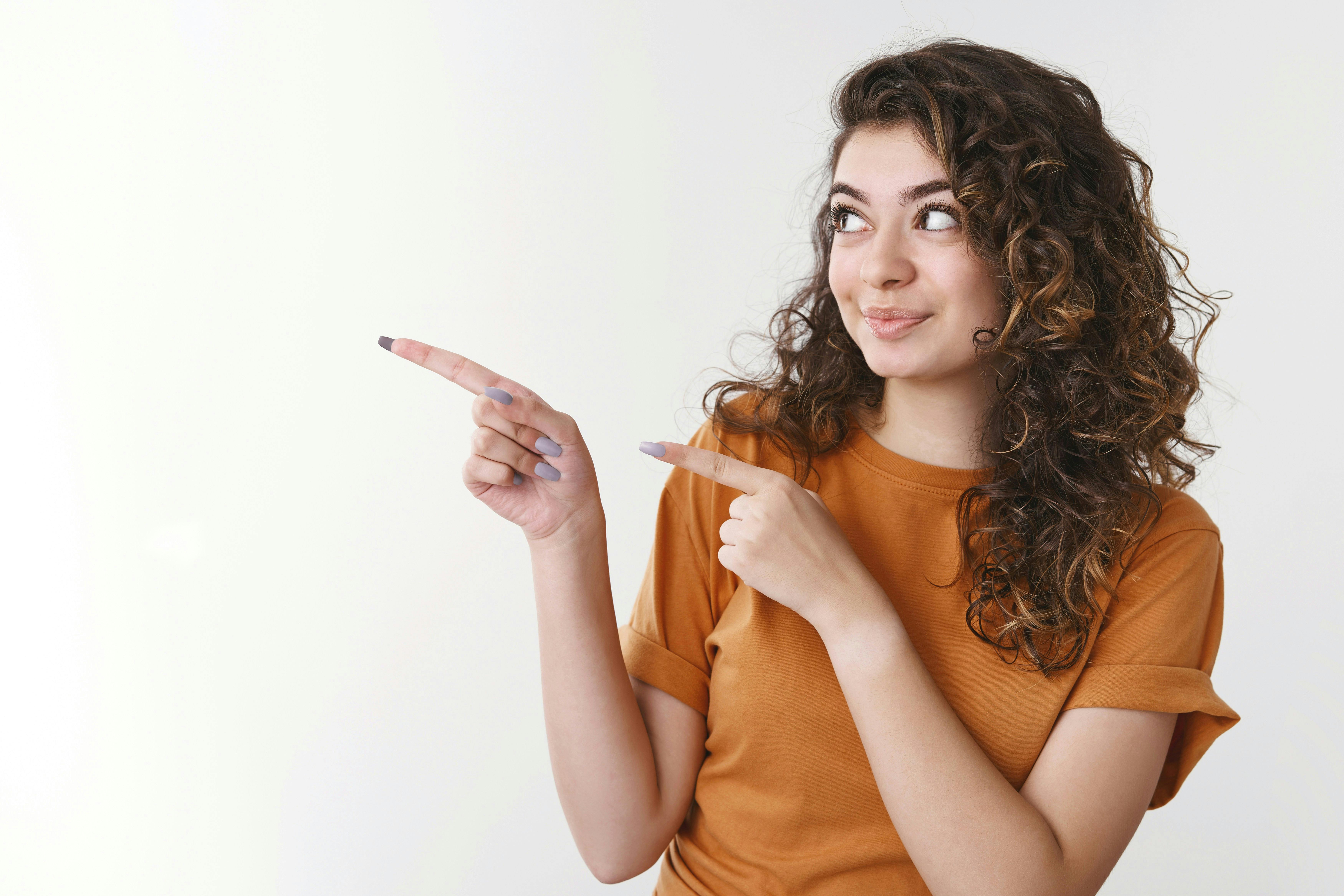 femme avec t-shirt jaune qui pointe du doigt vers la gauche