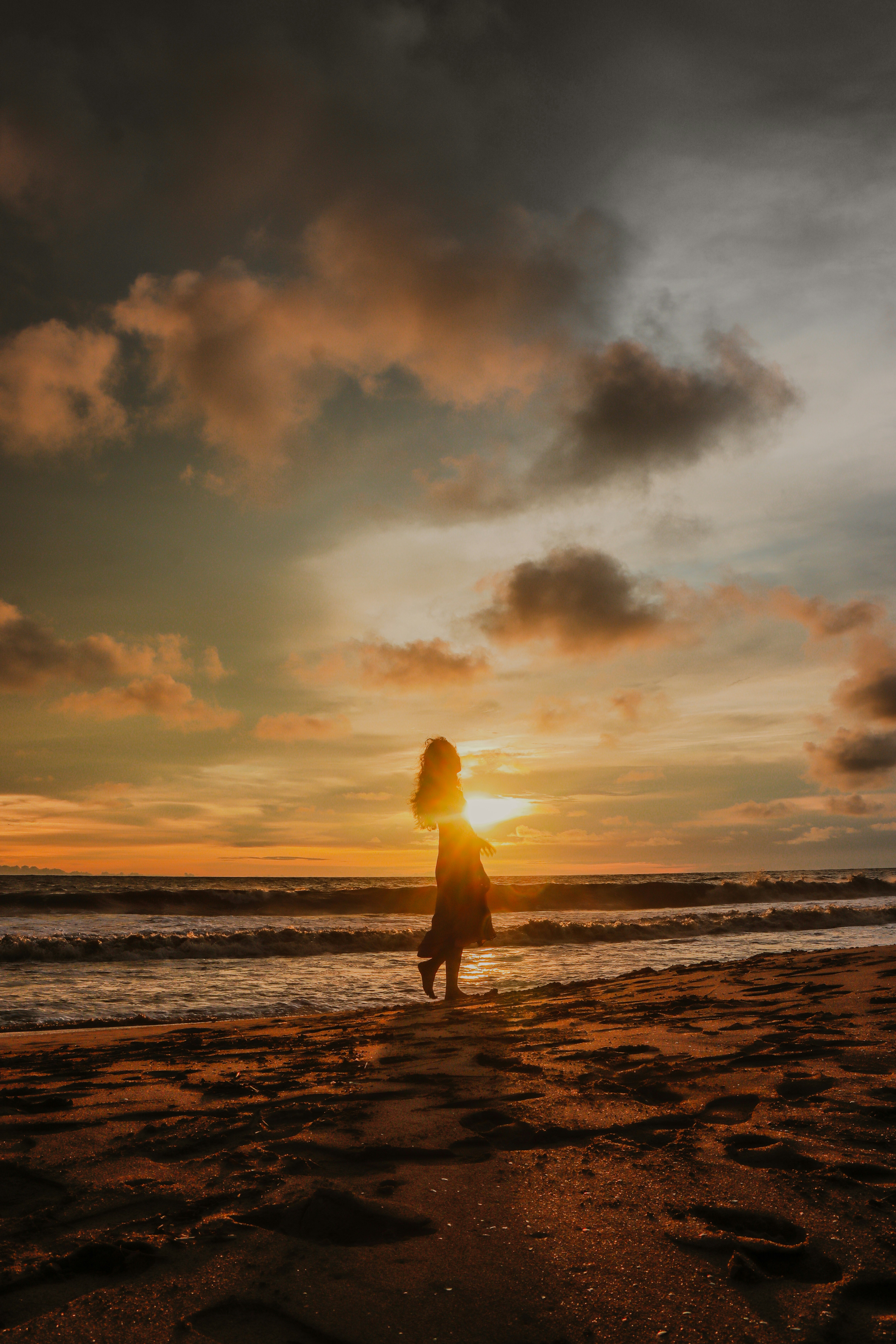 femme au bord de la mer et coucher de soleil
