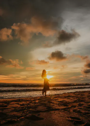 femme au bord de la mer et coucher de soleil