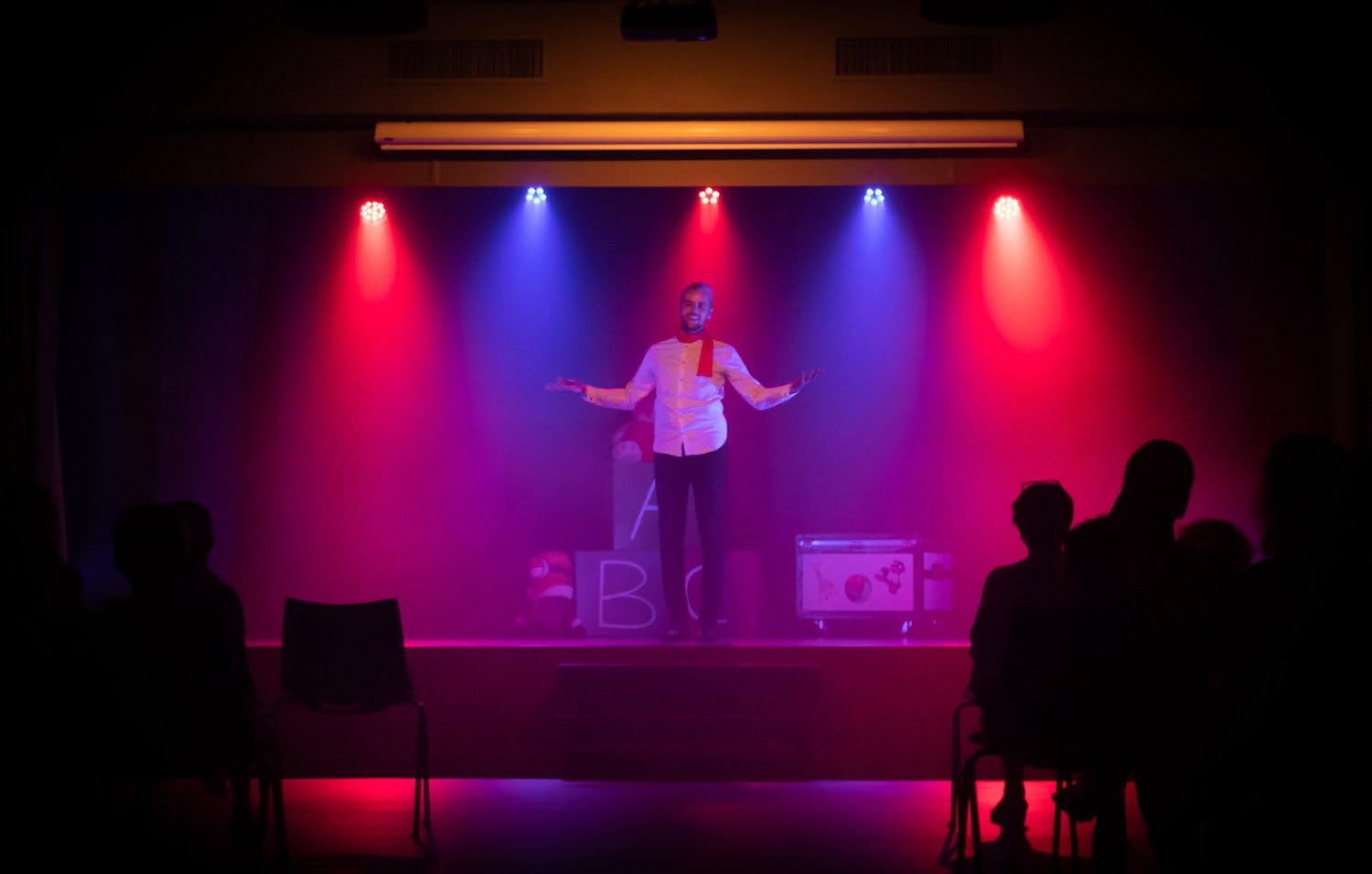 a person on a stage with colorful lights