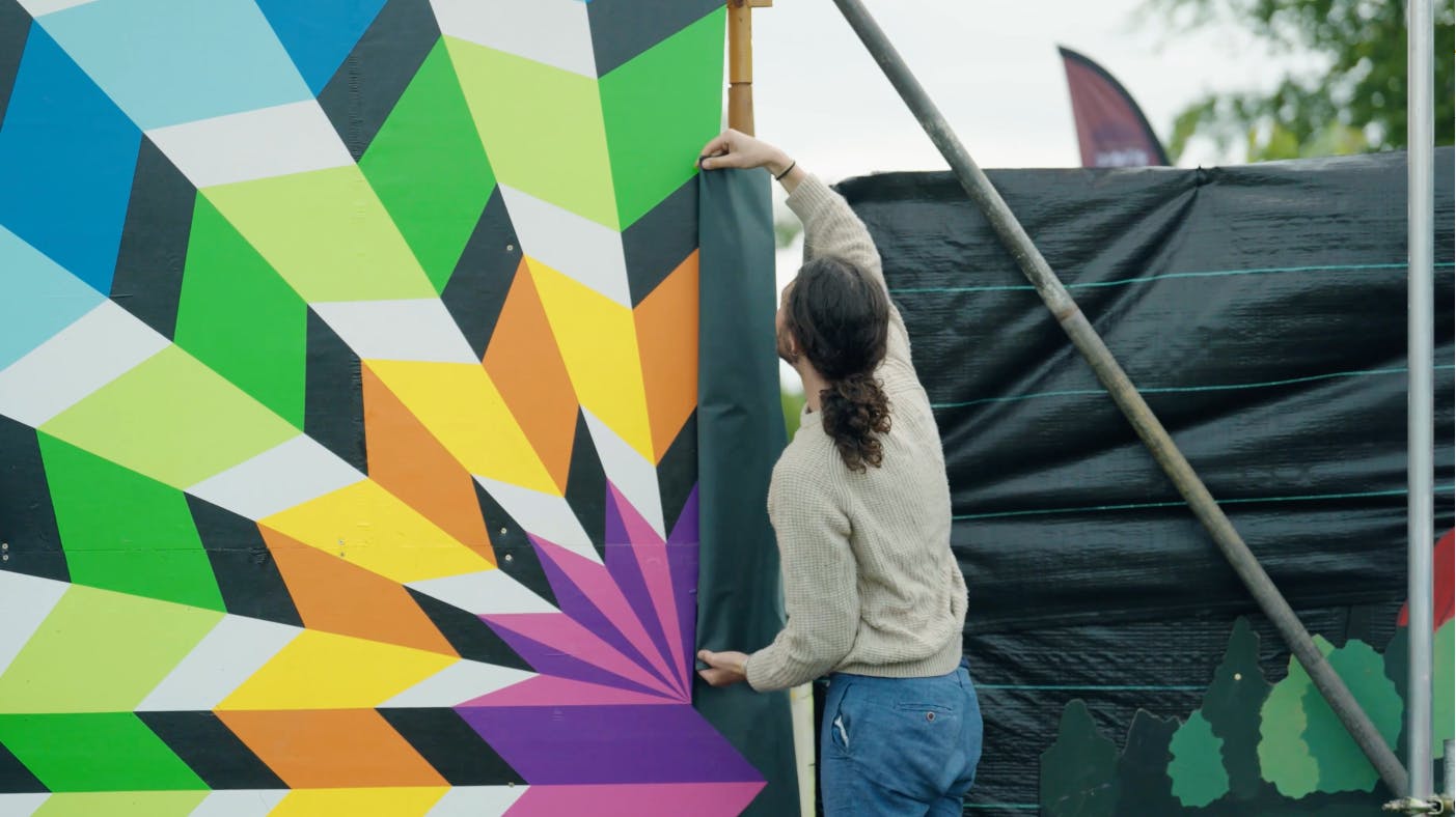 person fixing a colourful sign
