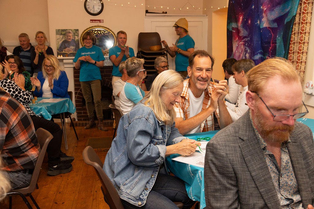 Group of people in pop-up pub by Dryad Gin, some sitting some standing