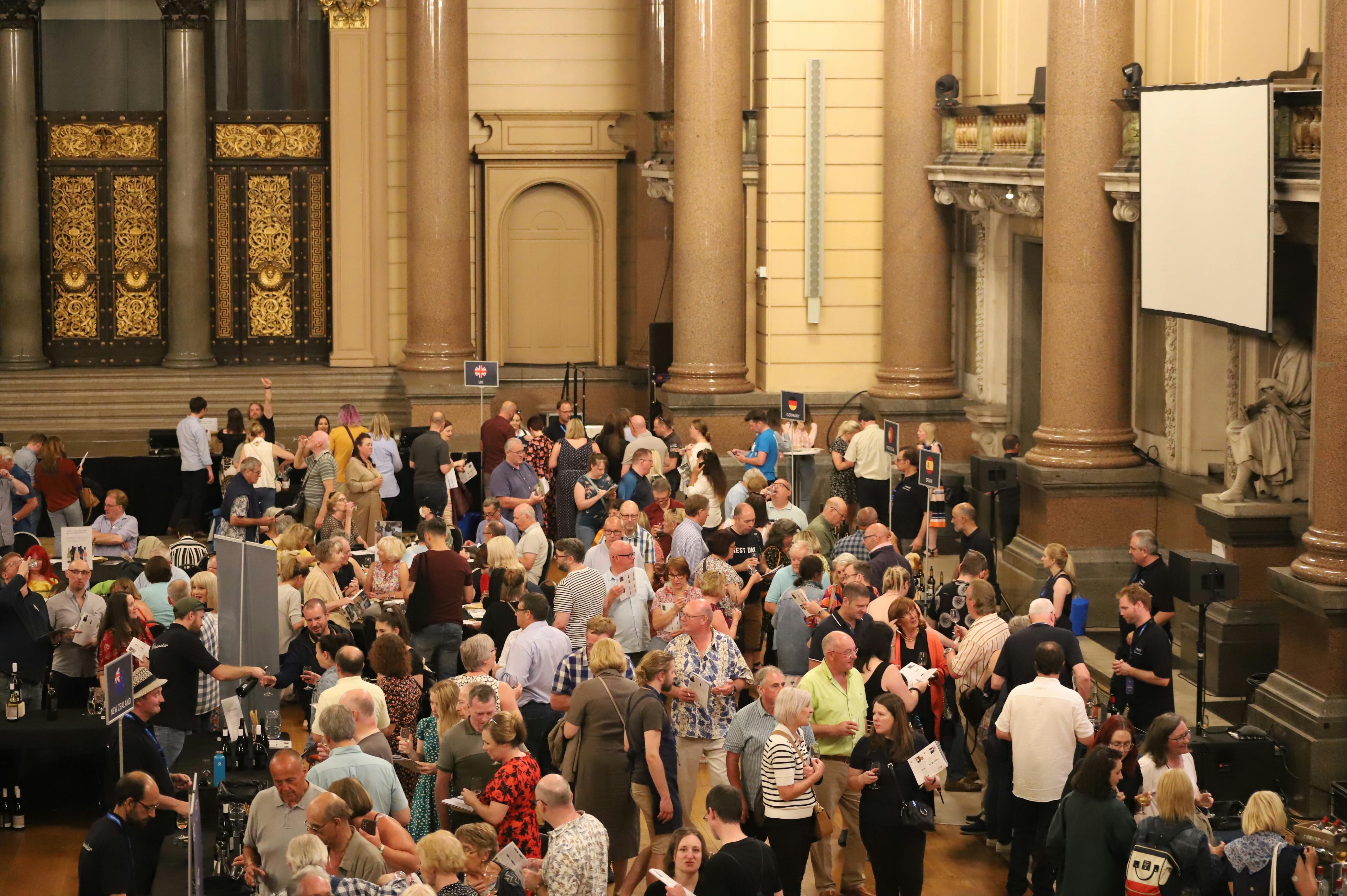 A group of people in a grand venue participating in the Naked Wines Tour