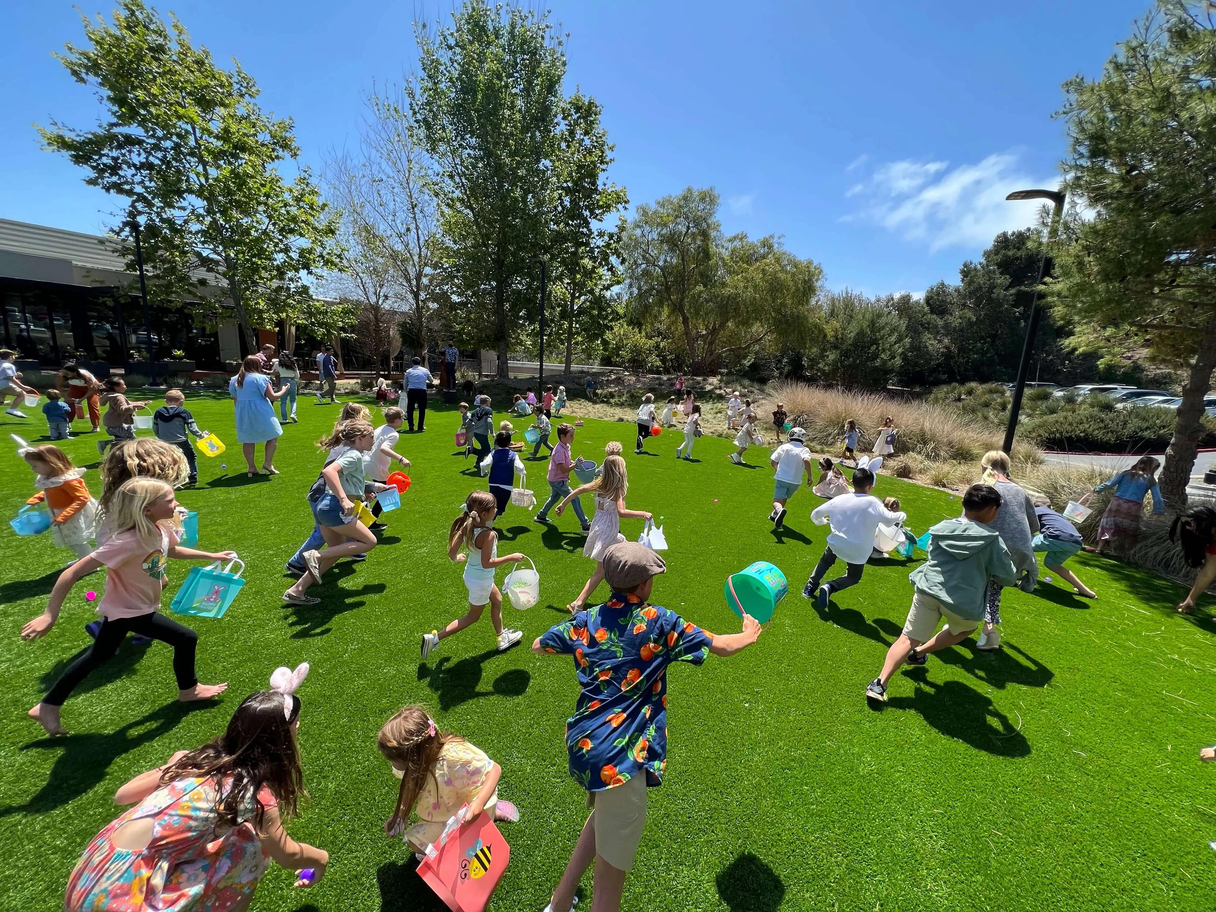 children running in sunny park during easter egg hunt