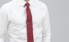 White button down shirt with a red tie and silver tie bar
