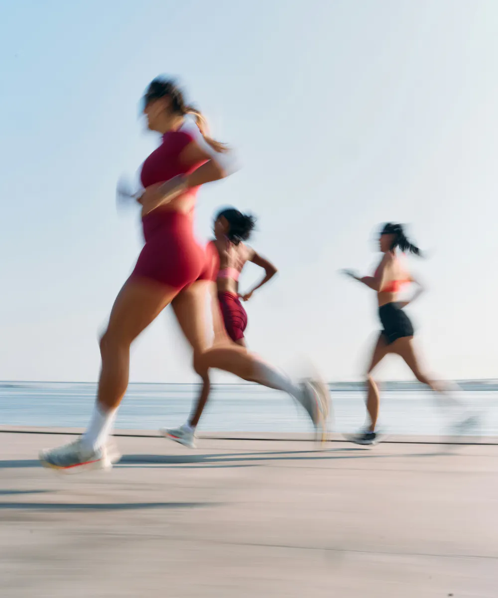 Runners in motion beside the sea, reflecting the energetic Life Shared colour story