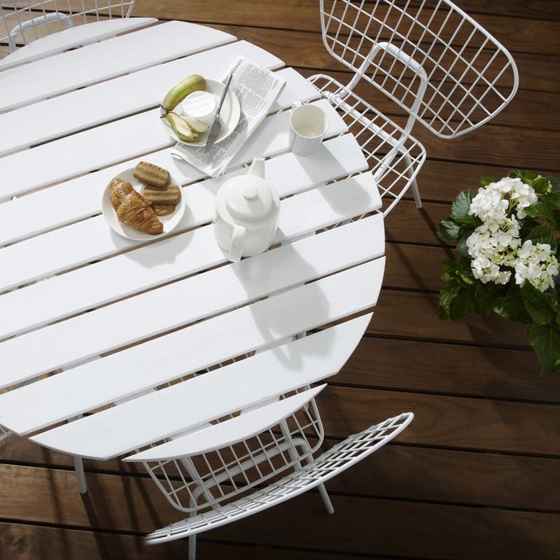 White wooden table and chairs on brown decking