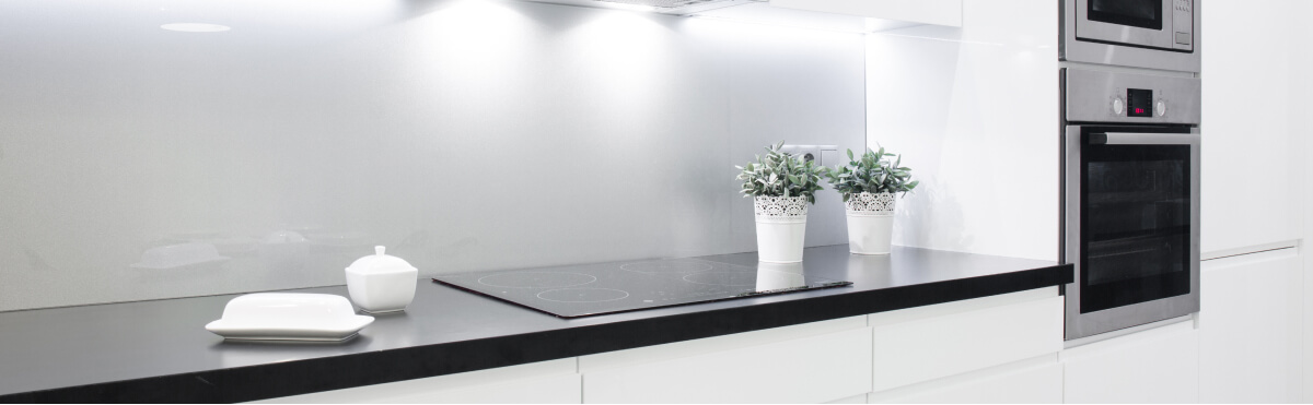 black kitchen worktop with a grey wall 