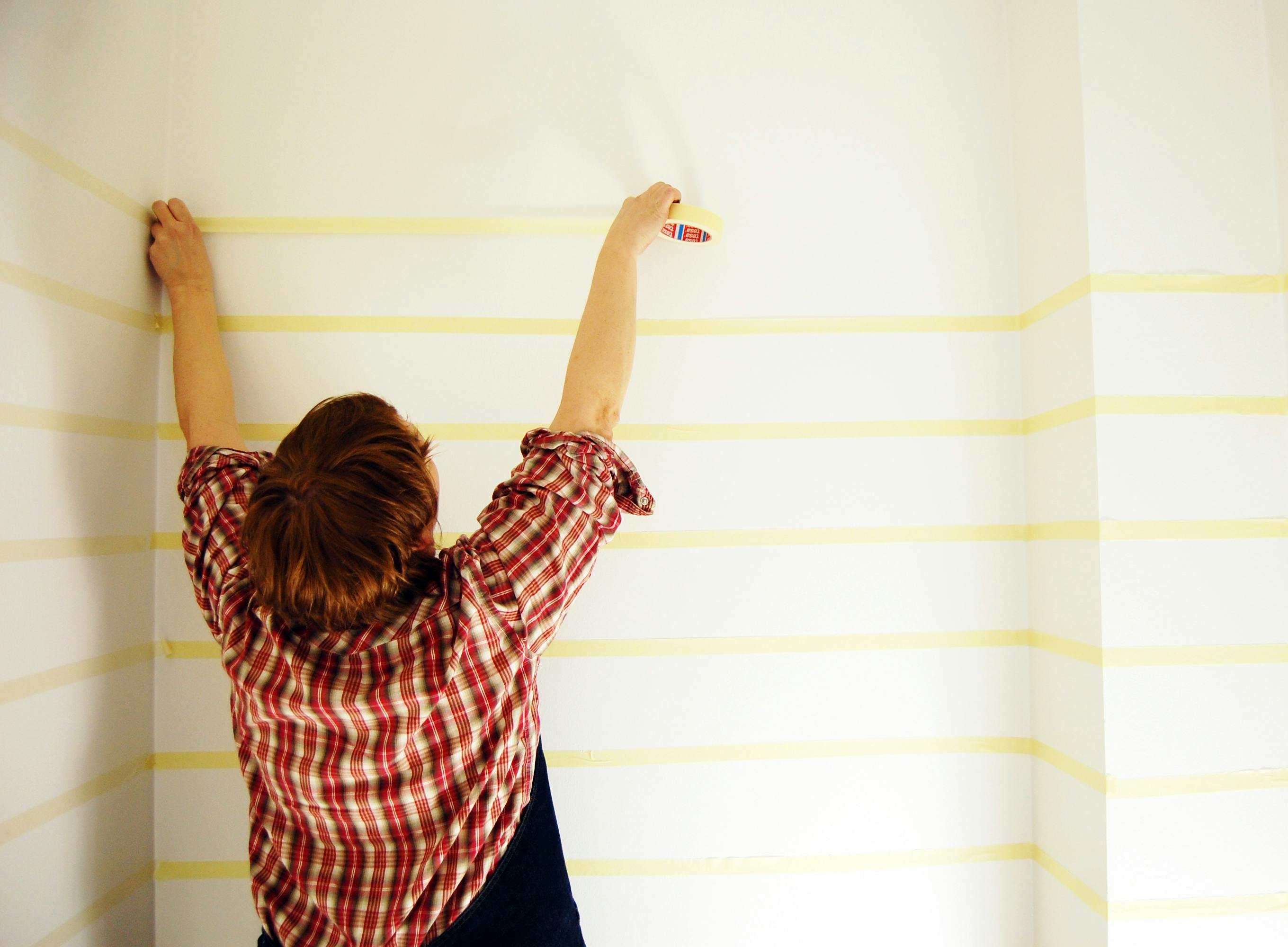 woman taping a wall