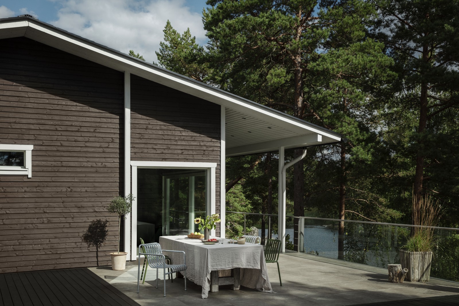 Hero Image | Garden furniture in front of dark brown house with wooden panels