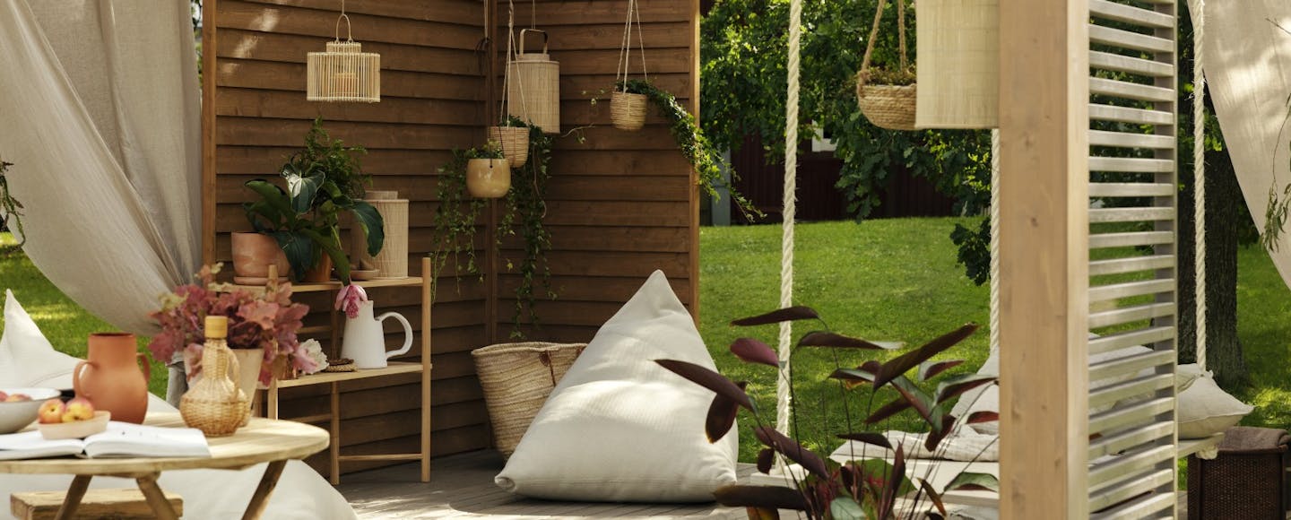 Pergola Wall with Wooden Accessories, Large Pillow and Hanging Plants