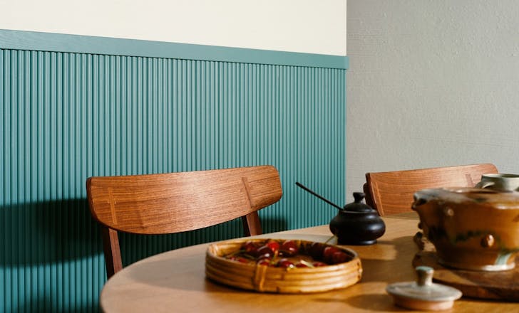 wooden chair and table in front of blue panelled wall