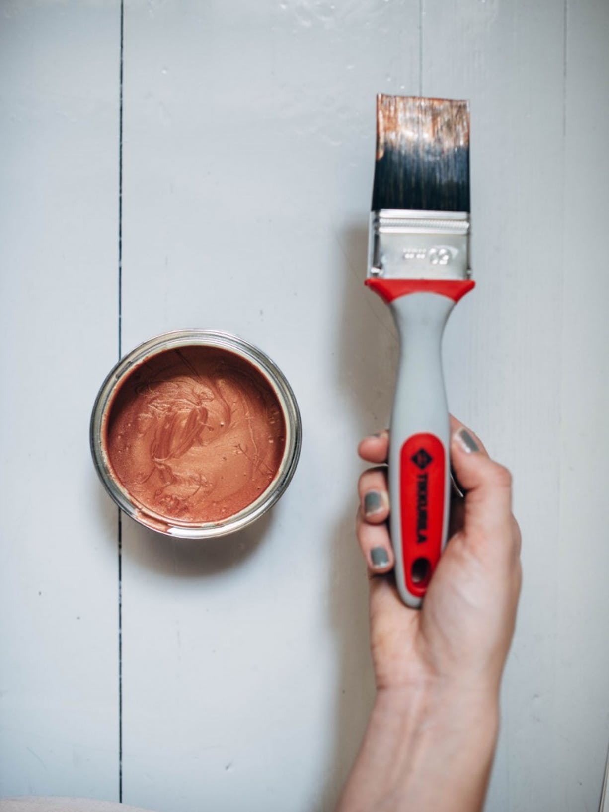 Open Paint Can with Copper Metallic Paint Inside and Hand Holding Paintbrush
