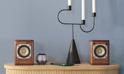 candle holder and speakers on wooden furniture against wall painted in dusky blue shade sandman v431