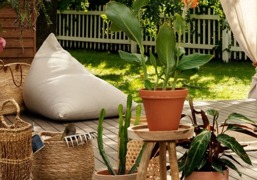 Terracotta Plant Pot on Wooden Stool with Rattan Baskets and Large Cream Pillow