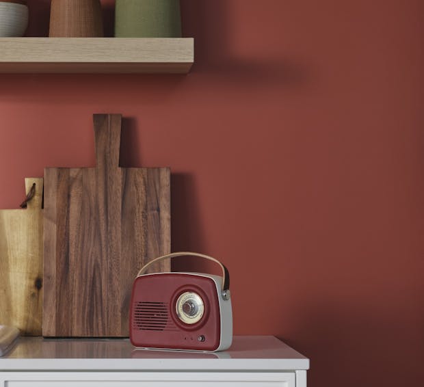 red radio on a kitchen counter in front of red wall painted in shade madras n411