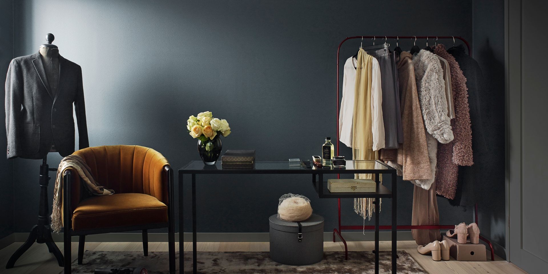 Deep Blue Living Room with Orange Armchair, Black Desk and Clothes on Rail