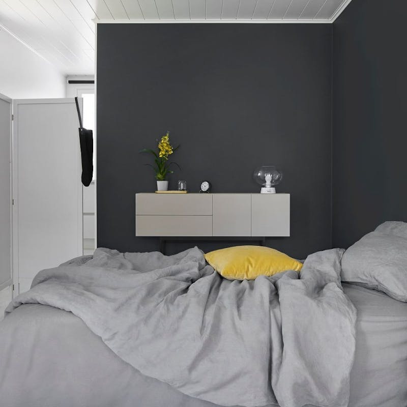 Grey Bed Against Dark Grey Feature Wall